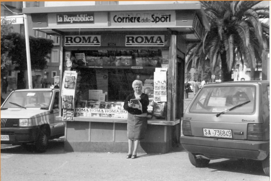 22 – Chiosco-edicola Stifano in piazza. In evidenza, la titolare (foto anni Ottanta – Associazione “Quattro Leoni”, album “Vallo, immagini da sfogliare”)